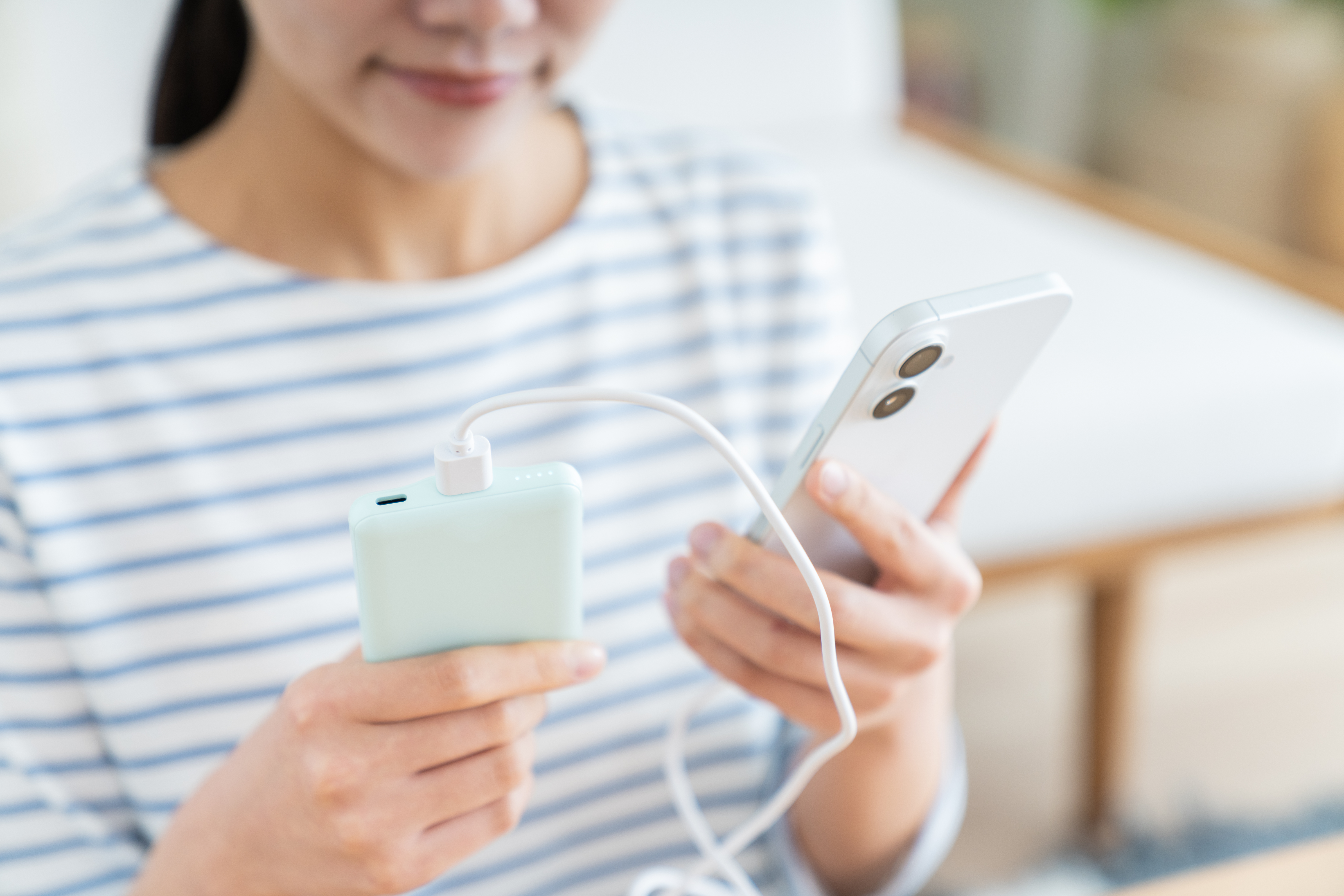 A young woman charging her smartphone